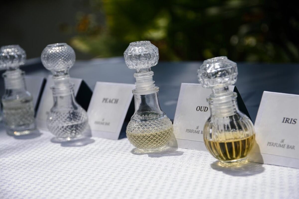 בקבוקי בושם עם שלטי תווים — IRIS, OUD, ROSE